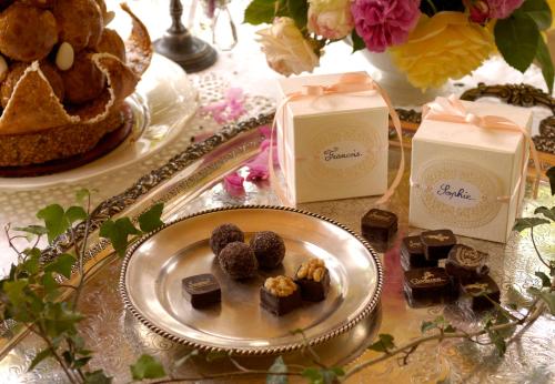 a plate of chocolates on a table with cakes and cakes at Le Moulin Bregeon in Linières-Bouton