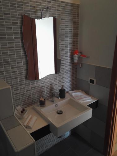 a bathroom with a sink and a mirror at Like Home Cisanello in Pisa