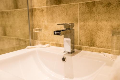 a sink in a bathroom with a faucet at Castle Hotel in Tamworth