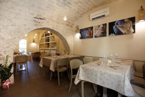 a restaurant with tables and chairs and a stone wall at Il Maramaldo Bed&Breakfast-Restaurant in Lajatico