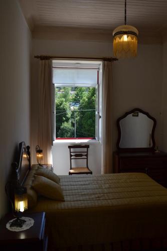 a bedroom with a bed and a window at Casa da Ponte do Arrocho in Loriga