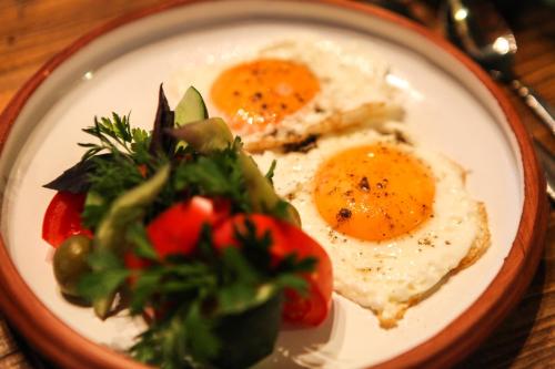 a plate of eggs and vegetables on a table at Guest house Dilijan Orran in Dilijan