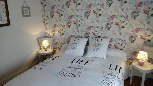een slaapkamer met een bed met bloemrijk behang bij La Roseraie de Gamaches in Gamaches