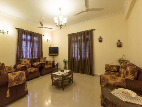 a living room with couches and a table at Saudades Homestays in Majorda