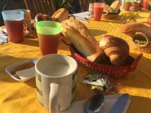 ein Tisch mit einer Tasse Kaffee und einem Korb Brot in der Unterkunft TANA-JACARANDA in Antananarivo