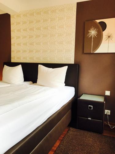 a hotel room with a bed and a night stand at Zum Fehmelbauer in Karlstadt
