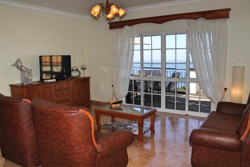 a living room with a tv and a couch and a table at OurMadeira - Casa Vista Bela in Estreito da Calheta