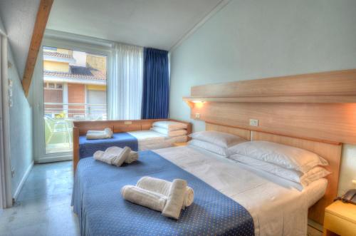 Säng eller sängar i ett rum på Hotel Mimosa