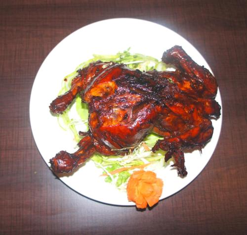 a plate of food with meat and vegetables on a table at The Loft Hotel, Siliguri in Siliguri