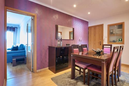 a dining room with a wooden table and a purple wall at In Bed with Lisbon 4E in Amadora