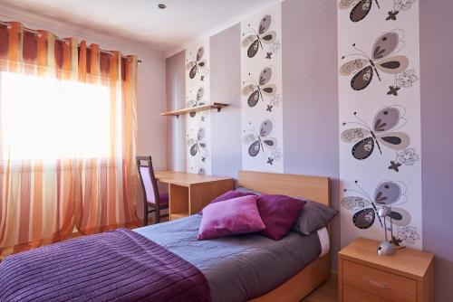 a bedroom with a bed and butterflies on the wall at In Bed with Lisbon 4E in Amadora