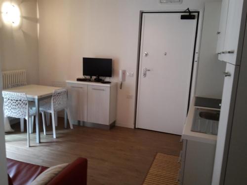 a small room with a table and a door with a television at Villaggio delle Alpi in Pré-Saint-Didier