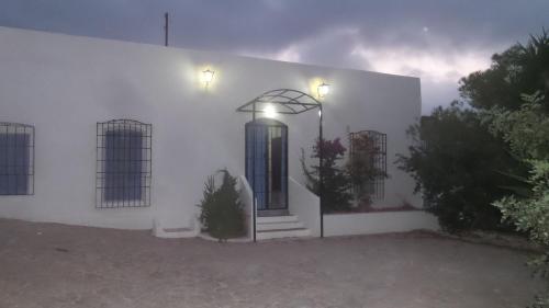 a white building with a door and a street light at Casa Rural La Fuensanta in Mojácar