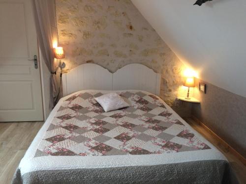 a bedroom with a bed with a quilt on it at Gîte du Ruisseau de la Renne in Thésée