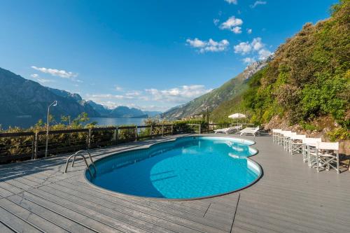 a swimming pool on a deck with a view of a mountain at Piccolo Hotel in Malcesine