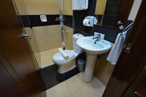 a bathroom with a toilet and a sink and a shower at Hotel Formosa Daet in Daet