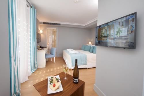 a room with a bed and a table with a bottle of wine at Aenos Hotel in Argostoli