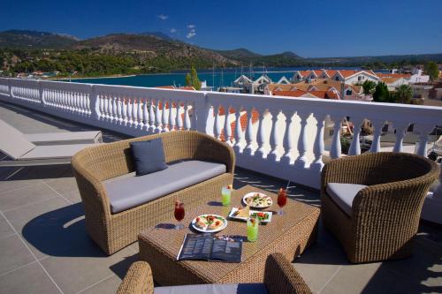 a balcony with two chairs and a table with food on it at Aenos Hotel in Argostoli