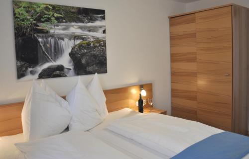 a bedroom with a white bed with a painting on the wall at Appartement Romana - Altstadt in Schladming