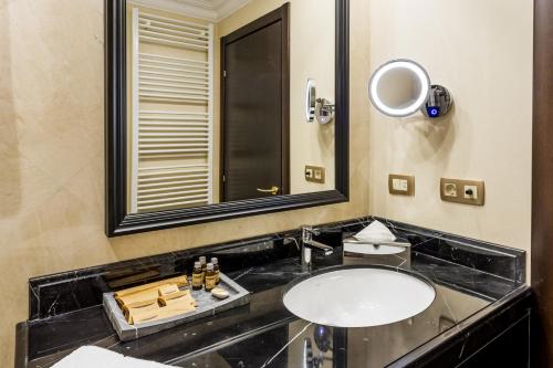 a bathroom with a sink and a mirror at Hotel Prahova Plaza in Ploieşti