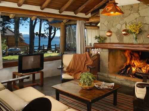a living room with a fireplace and a tv at HTL La Malinka in San Carlos de Bariloche