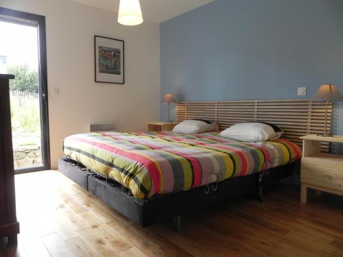 トレブールダンにあるTy Bugale Bihanのベッドルーム1室(大型ベッド1台、カラフルな毛布付)