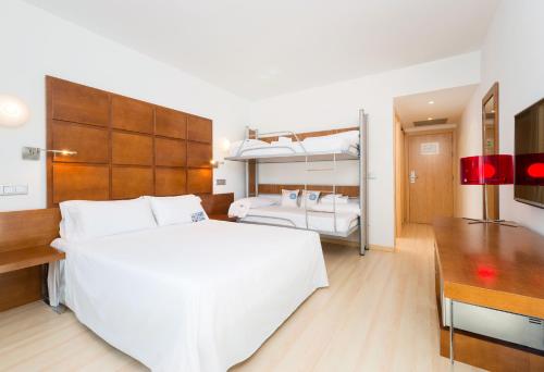 a bedroom with a white bed and two bunk beds at Hotel Zentral Ave in Zaragoza