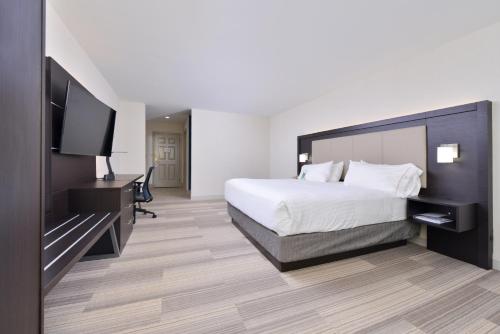a hotel room with a bed and a flat screen tv at Holiday Inn Express Mystic by IHG in Mystic