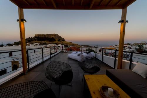 a balcony with a table and chairs and a view of the ocean at Villa Myrto in Líndos