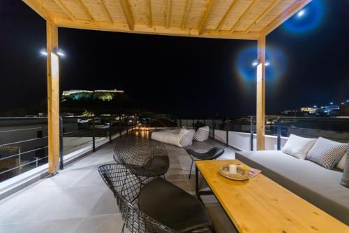 a balcony with a couch and a table with chairs at Villa Myrto in Líndos