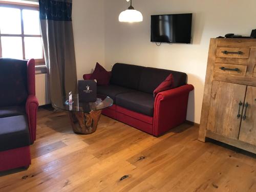 a living room with a couch and a table with a laptop at Landhaus Kössel in Füssen