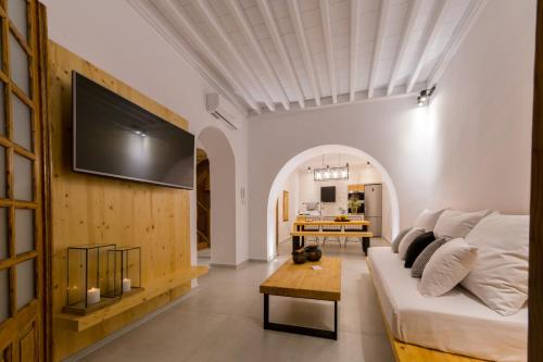 a living room with a couch and a tv on a wall at Villa Myrto in Líndos