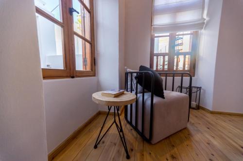a room with a chair and a table and windows at Villa Myrto in Líndos