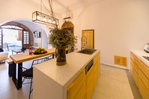 a kitchen with a table with a vase of flowers on it at Villa Myrto in Líndos