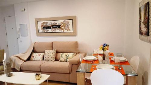 uma sala de estar com um sofá e uma mesa em Apart. Céntrico San Miguel em Córdoba