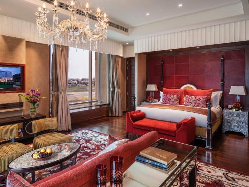 a hotel room with a bed and a chandelier at Taj Santacruz in Mumbai