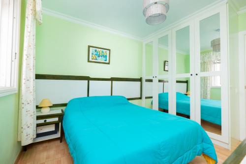 マスパロマスにあるLos Robles Verdesのベッドルーム(青いベッド1台、窓付)