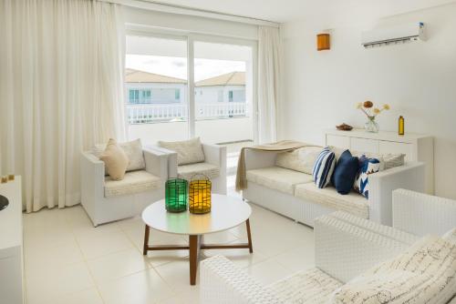 a living room with white furniture and a large window at Tree Bies Resort - Oficial in Subaúma
