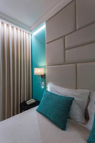 a hotel room with a bed with a blue pillow at Josefa D`Obidos Hotel in Óbidos