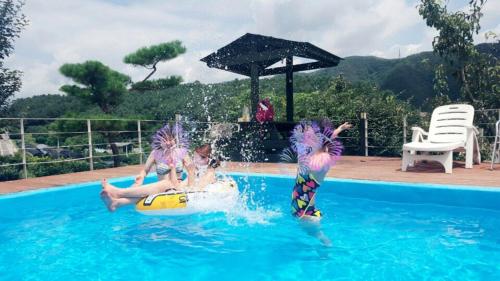 two children are playing in a swimming pool at Walking Sky Pension in Gapyeong