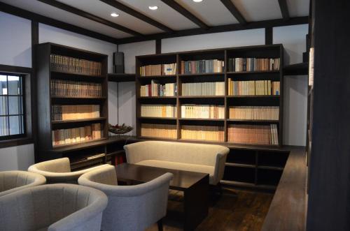 a library with couches and book shelves with books at 高野山 宿坊 不動院 -Koyasan Shukubo Fudoin- in Koyasan