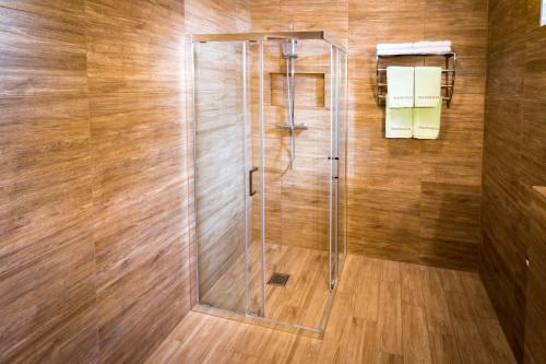 y baño con ducha y puerta de cristal. en Magnolia Hotel&Restauracja, en Jawor