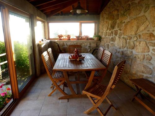 a wooden table and chairs on a patio at Casa da Eira Velha in Vale de Cambra