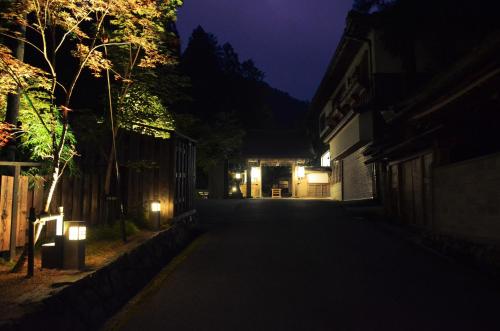 an empty street at night with lights on the sidewalk at 高野山 宿坊 不動院 -Koyasan Shukubo Fudoin- in Koyasan