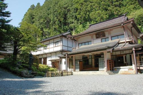 a japanese building with a mountain in the background at 高野山 宿坊 不動院 -Koyasan Shukubo Fudoin- in Koyasan