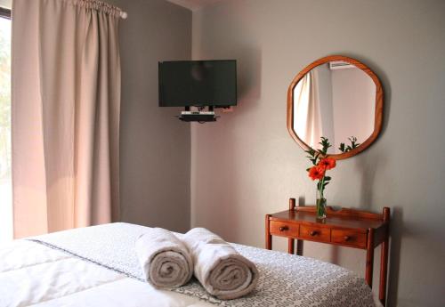a bedroom with a mirror and towels on a bed at Hotel Zapata in Boca Chica