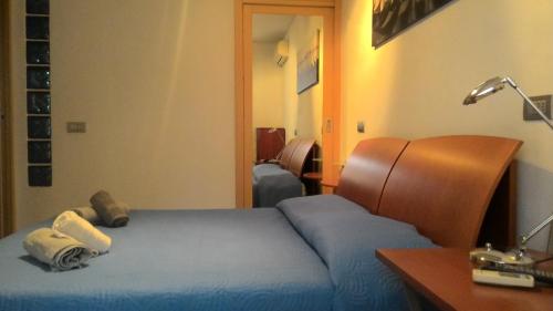 een slaapkamer met 2 bedden, een bureau en een lamp bij Appartamento Teodorico in Verona
