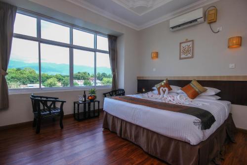 a bedroom with a large bed with a large window at Immana Grand Inle Hotel in Nyaung Shwe