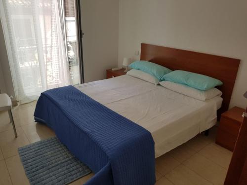 サン・ベネデット・デル・トロントにあるMentanaのベッドルーム(青い枕の大型ベッド1台付)
