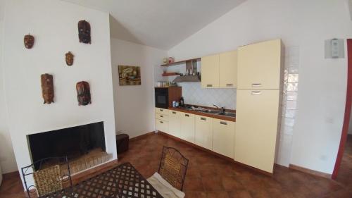 ヴィッラシミーウスにあるTrivano panoramicoの白いキャビネットと暖炉付きのキッチン